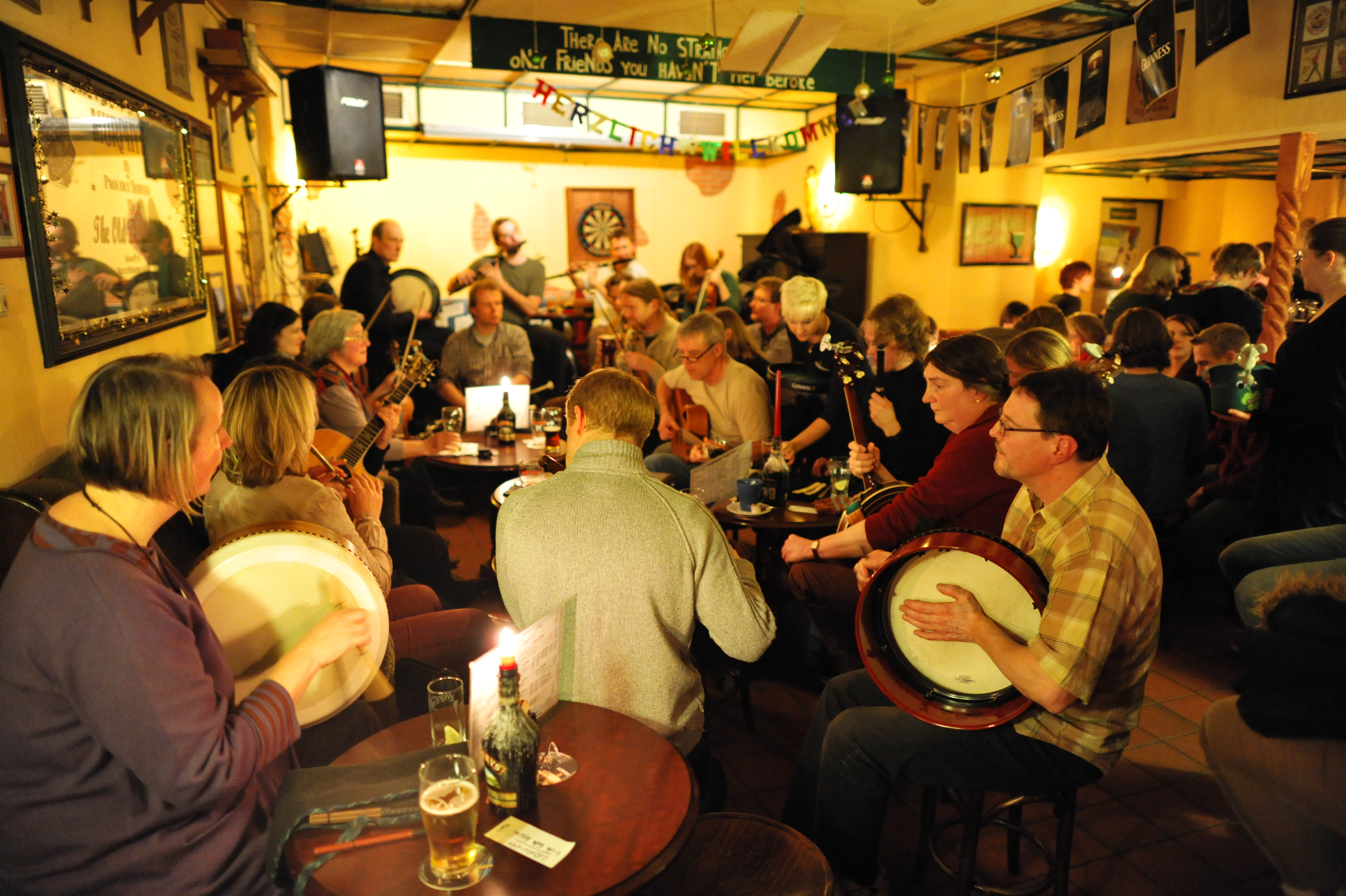 Musicians with bodhráns, fiddles and guitars at a busy Irish folk session in the Old Dubliner pub, Hamburg-Harburg